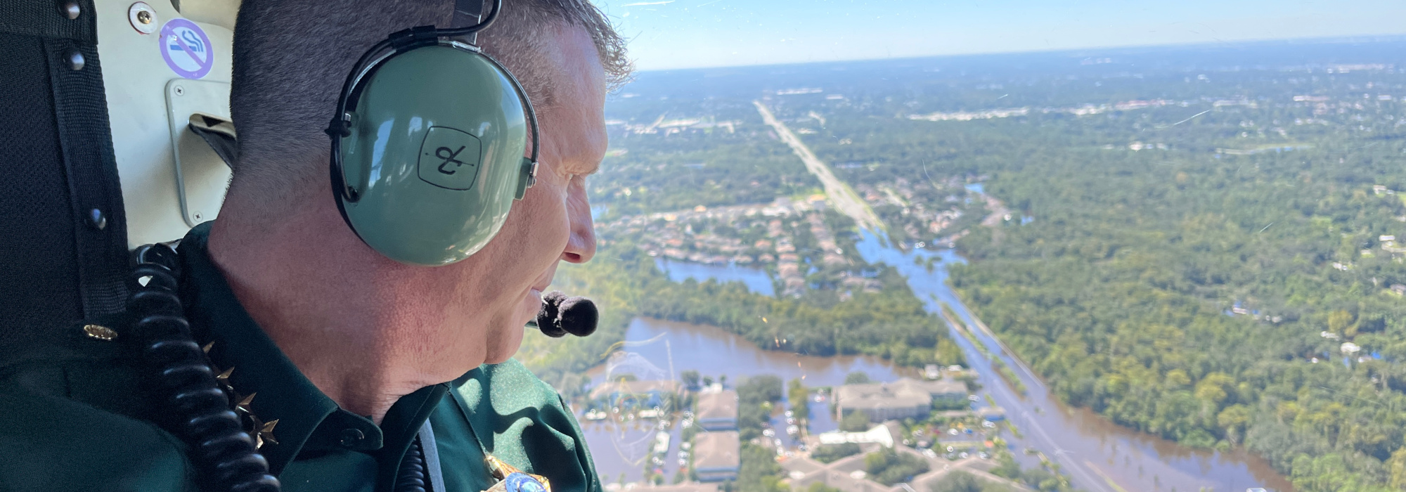 Sheriff Mina riding in a helicopter looking over the city