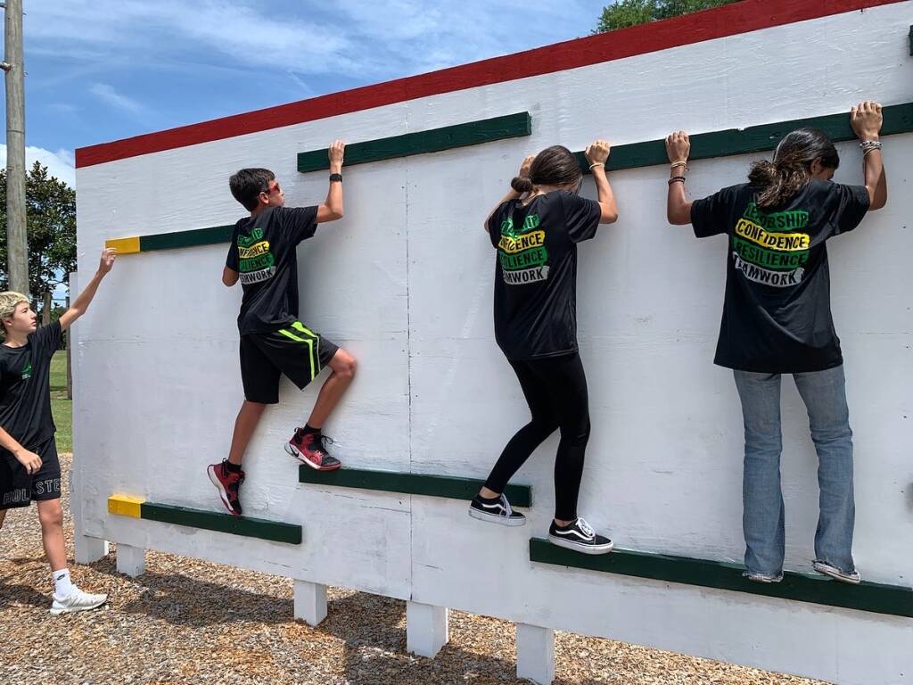 four teen academy students crossing an obstacle